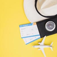 kaartjes met paspoort, hoed en vliegtuig op gele achtergrond foto
