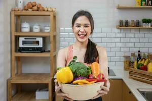 Aziatisch huisvrouw is tonen verscheidenheid van biologisch groenten naar bereiden gemakkelijk en gemakkelijk Japans schotel naar koken salade maaltijd voor veganistisch en vegetarisch ziel voedsel concept foto