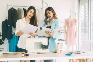 twee vrouw mensen kleermaker werken in mode ontwerp werkplaats studio foto