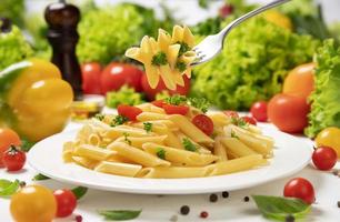 plaat van Italiaanse pasta op vork met tomaten en basilicum foto