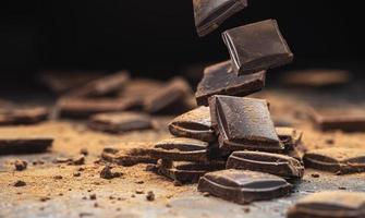 vallende gebroken chocoladerepen op zwarte achtergrond foto