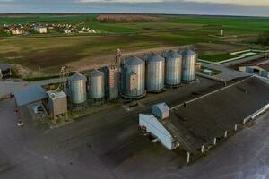 antenne panoramisch visie Aan agro-industrieel complex met silo's en graan drogen lijn voor drogen schoonmaak en opslagruimte van ontbijtgranen gewassen foto