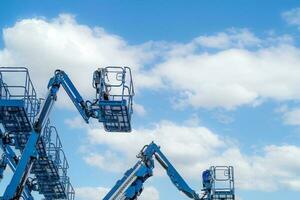 gearticuleerd boom tillen. antenne platform tillen. telescopisch boom optillen tegen wit cumulus wolken lucht. mobiel bouw kraan voor huur en uitverkoop. onderhoud en reparatie hydraulisch boom optillen onderhoud. foto