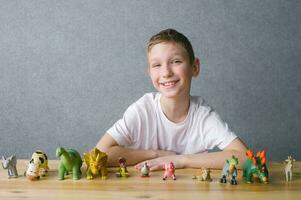 schattig jongen zetten dier figuren Aan de tafel, Speel met speelgoed foto