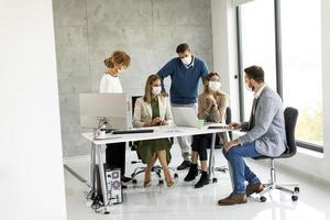 gemaskerde professionals in een vergadering in een modern kantoor foto