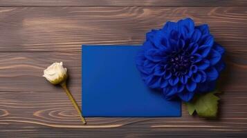 blanco blauw papier kaart mockup met dahlia bloem Aan houten tafel bovenkant, generatief ai. foto