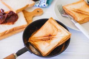 geroosterd toastbrood dat opduikt uit een roestvrijstalen broodrooster in een huiskeuken. foto