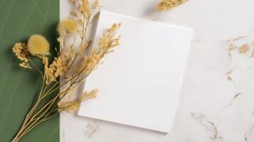 top visie van blanco papier met droog gras bloem Aan groen en wit marmeren achtergrond en plaatsing. voorjaar of bruiloft kaart ontwerp. generatief ai. foto