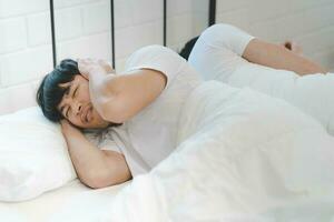 Aziatisch lgbt homo paar hebben problemen in bed. een Mens covers zijn oren met zijn handen van de geluid van snurken. foto