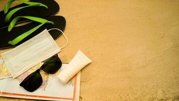 slippers, masker, tinten, kaart en gel Aan zand. reizen na quarantaine samenstelling foto