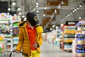 coronovirus bescherming. een kind in een gas- masker met een coronovirus infectie. jongen in een op te slaan in persoonlijk beschermend apparatuur. Mens verdedigt zichzelf tegen covid 19.coronavirus en paniek buying concept foto