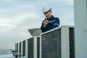 Aziatisch onderhoud ingenieur werken Aan kleur achtergrond, aannemer inspecteren compressor systeem en plannen installatie van lucht staat systemen in bouw. technologie, walky spraakzaam, onderhoud foto