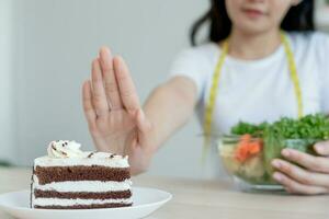 schoonheid slank vrouw lichaam verwarren dik voedsel. vrouw in restaurant behaalt gewicht verlies doel voor gezond leven, laag calorie, dun taille, voedingsdeskundige. eetpatroon, lichaam vorm geven aan, balans controle, voorkomen, voedingswaarde foto