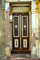 een houten dubbele deur, met donker bruin ramen met een steen muur. foto