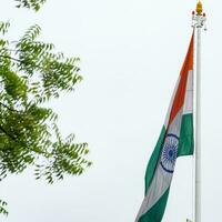 indiase vlag hoog op connaught plaats met trots in blauwe lucht, indiase vlag wapperen, indiase vlag op onafhankelijkheidsdag en republiek dag van india, tilt-up shot, wuivende indische vlag, har ghar tiranga foto