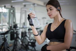 vrouw drinkwater in de sportschool foto