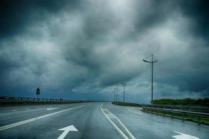 natte wegmarkeringen onder een donkere stormachtige lucht in de regio Kaliningrad foto