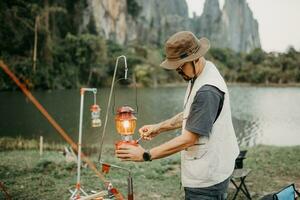 jong camper verlichting een lantaarn de solo camping in Laos foto