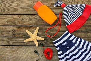 zomer kinderen kleding en strand accessoires voor uw zee vakantie Aan de oud houten achtergrond. afgezwakt afbeelding. foto