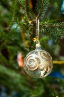 glas bal met gouden ornament Aan Kerstmis boom foto