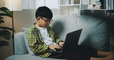 slim jongen gebruik laptop computer naar aan het leren online Bij huis foto
