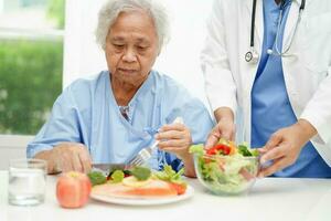 Aziatisch voedingsdeskundige Holding gezond voedsel voor geduldig in ziekenhuis, voeding en vitamine. foto