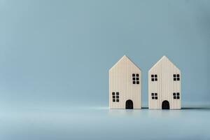 klein houten huis Aan licht blauw achtergrond voor echt landgoed en woon- gebouw concept. weinig huis model- met kopiëren ruimte. foto