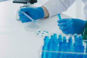 hand- van wetenschapper met test buis en fles in medisch chemie laboratorium blauw banier achtergrond foto