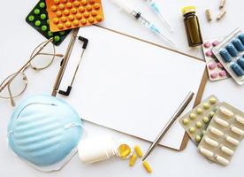 Klembord blauw medisch masker en medicijnpillen foto