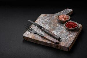 mes, vork en snijdend bord, zout, peper en andere ingrediënten foto
