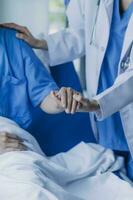 dokter controleren omhoog na chirurgie. dokter aanraken geduldig hand- en troostend. foto
