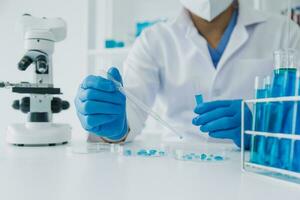 hand- van wetenschapper met test buis en fles in medisch chemie laboratorium blauw banier achtergrond foto
