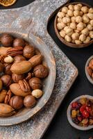 mengen van geroosterd macadamia noten, cashewnoten, pecannoten, amandelen, rozijnen en droog bessen foto
