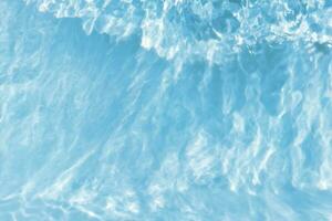blauw water met rimpelingen Aan de oppervlak. onscherp wazig transparant blauw gekleurde Doorzichtig kalmte water oppervlakte structuur met spatten en bubbels. water golven met schijnend patroon structuur achtergrond. foto