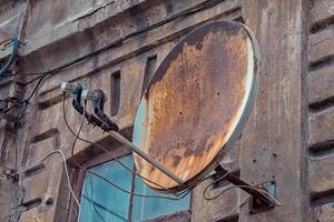 roestige schotelantenne op een oud huis foto