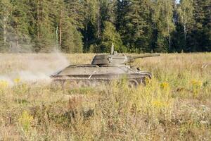 Moskou, Rusland, 25-08-2018, tentoonstelling van leger apparatuur, Scherm van leger uitrusting in actie. een leger tank in beweging tegen de achtergrond van groen bomen. foto