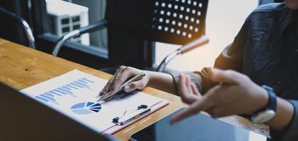 close-up van zakenvrouw met behulp van een rekenmachine om wiskunde te doen voor financiën op een houten bureau in een kantoor met een zakelijke achtergrond, belasting, boekhouding, statistiek en analytisch onderzoek foto