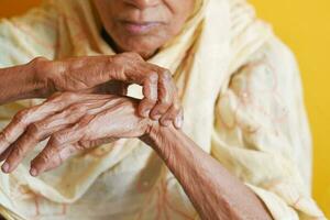 ouderen vrouw lijden pijn Aan hand- foto