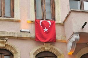 laag hoek visie van Turks vlag hangende Aan een gebouw foto