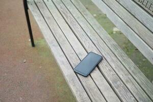 vergeten smartphone Aan een park bank, verloren slim telefoon foto
