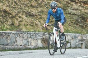 Mens fietser Aan weg klimt foto