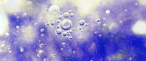 olie bubbels dichtbij omhoog. cirkels van water macro. abstract licht blauw achtergrond. banier foto