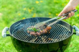 heerlijk sappig steak roosteren Aan een rooster in voorjaar zonlicht foto