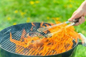 heerlijk entrecote sissend Aan een bbq met een veel van brand en rook foto