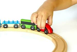 een kind Toneelstukken met een trein gemaakt van hout. detailopname van een kind hand. foto