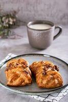 rieten broodjes met kaneel, noten en esdoorn- siroop en een kop van koffie voor Zweeds fika tijd verticaal foto