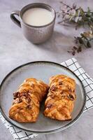 Zweeds fika tijd met vers kaneel broodjes en een kop van latte Aan de tafel verticaal visie foto