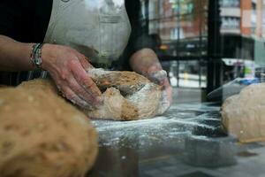 dichtbij omhoog van werken handen in een bakkerij foto