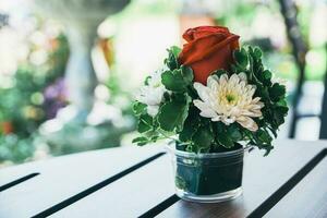 roos bloem rood Aan houten tafel foto