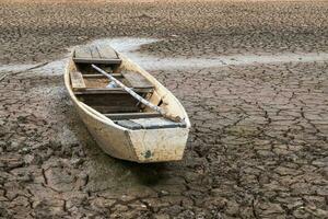 houten boot Aan klimaat droogte, terrein gebarsten bodem in heet weer foto